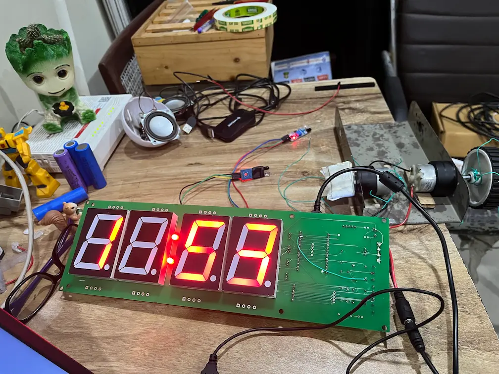 Bench test of the hoop alarm clock with the lit 7-segment board and the IR sensor modules wired in on a desk